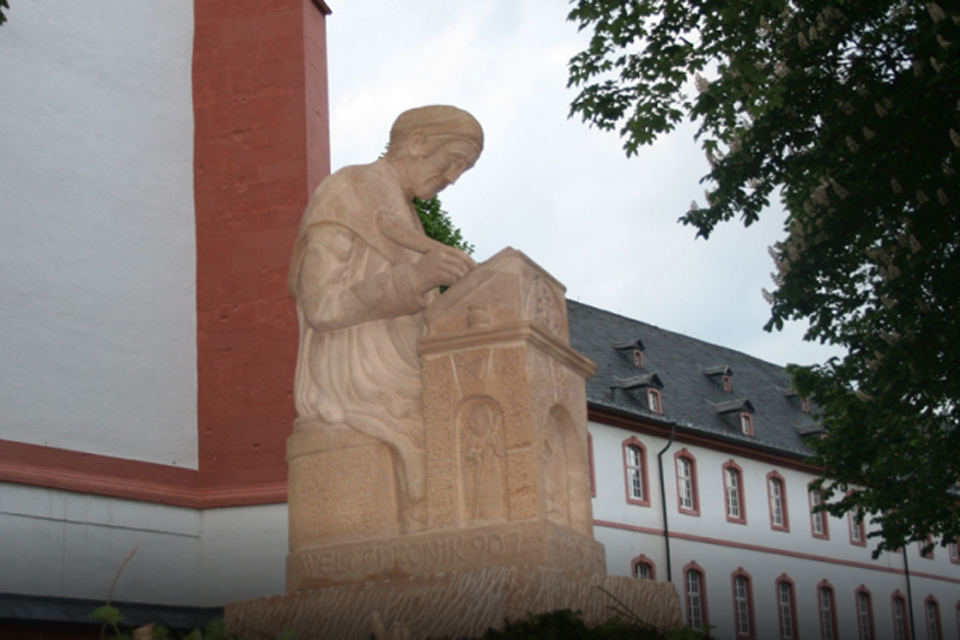 Regino of Prühm - Staue by peter Weiland in front of former Abbey. Source Abbey School